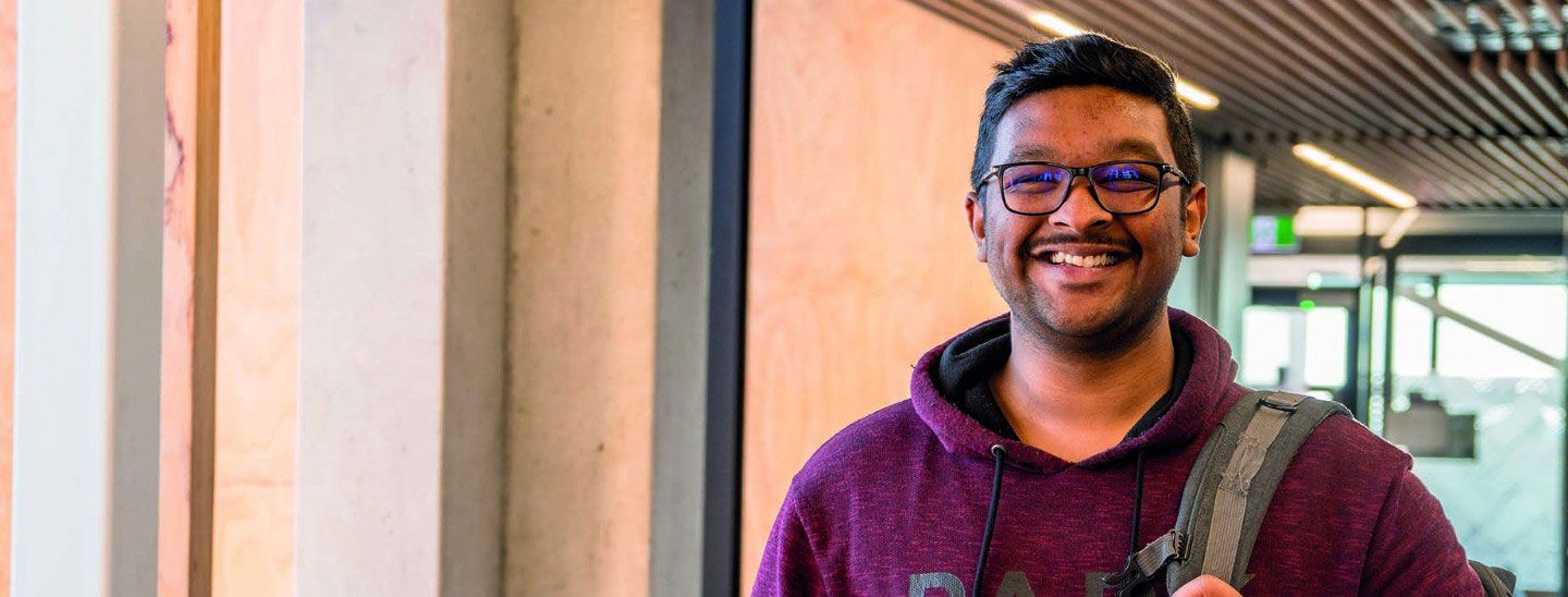 Male student portrait inside campus smiling