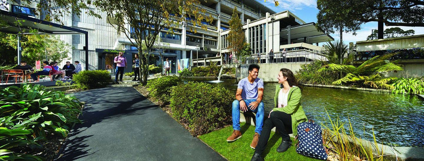 Students outside near water sitting talking